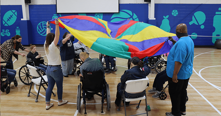 people playing with parachute in gymnasium